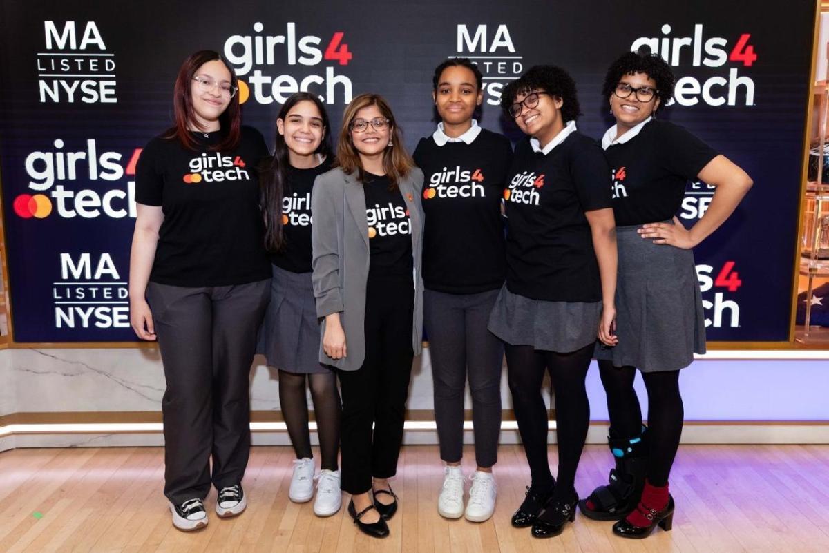 Six people in matching "girls4tech" shirts