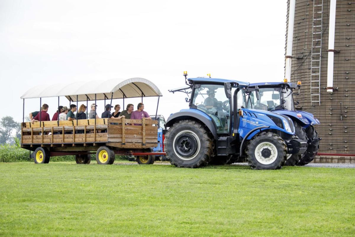 A blue tractor pulling people in a wagon