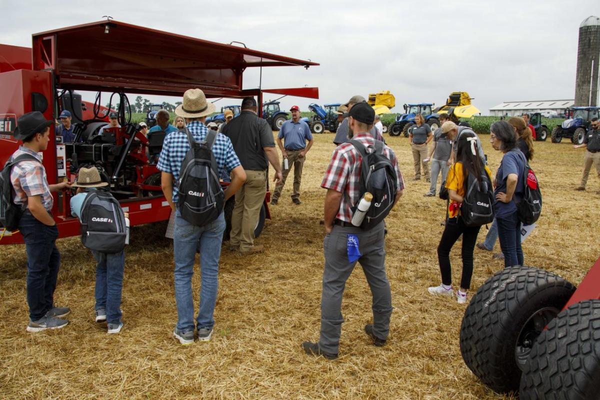 people in a field with tractors