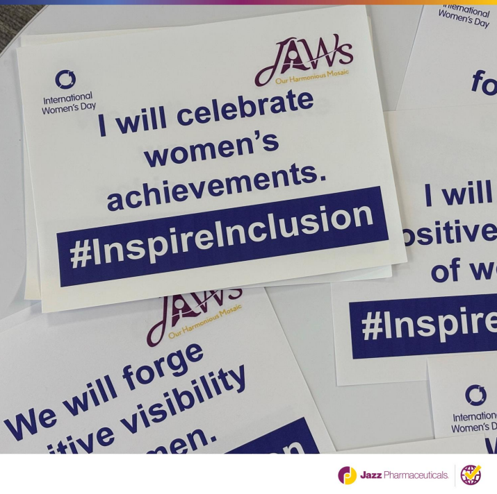 Papers on a table "I will celebrate women's achievements. #inspireinclusion".