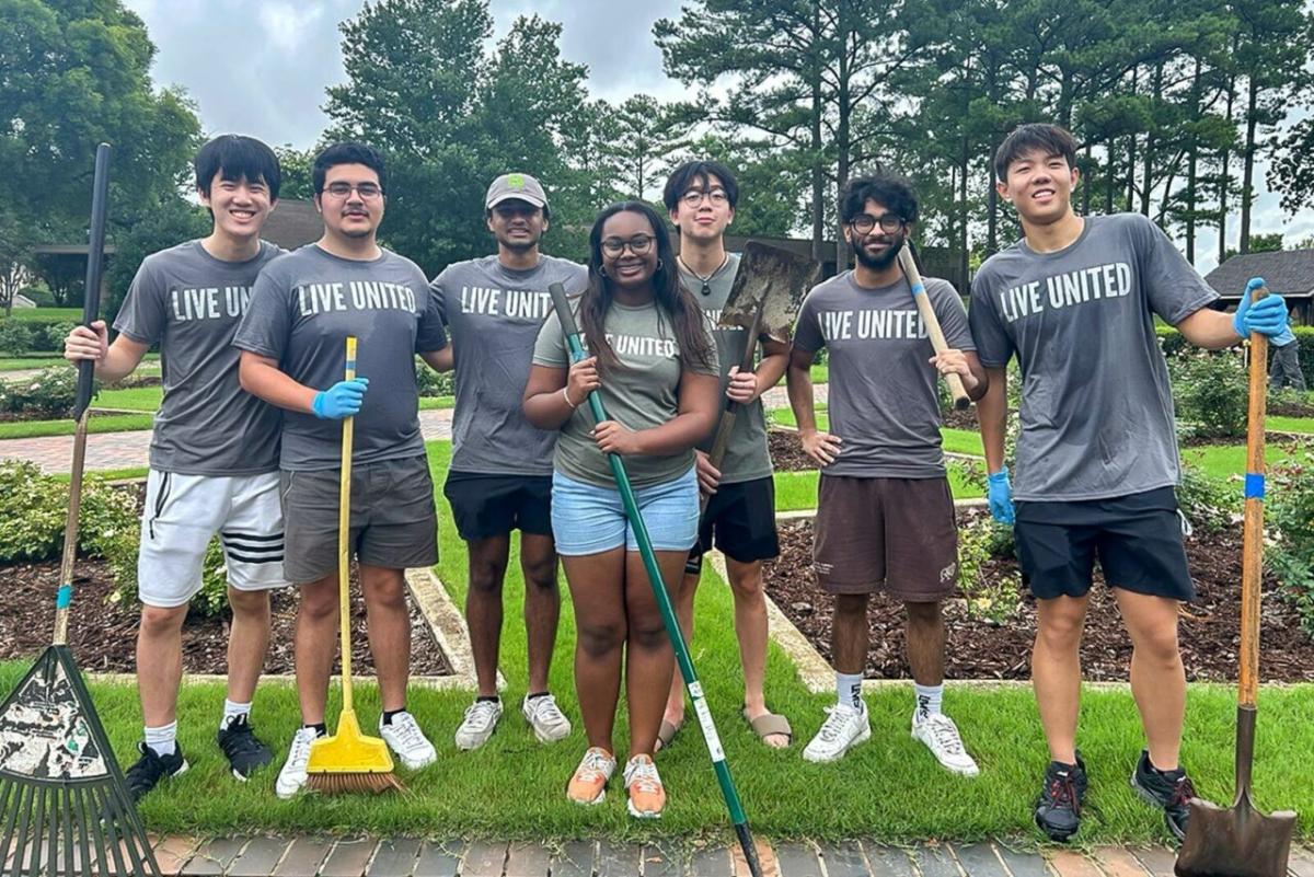 A group of volunteers posed with garden tools.