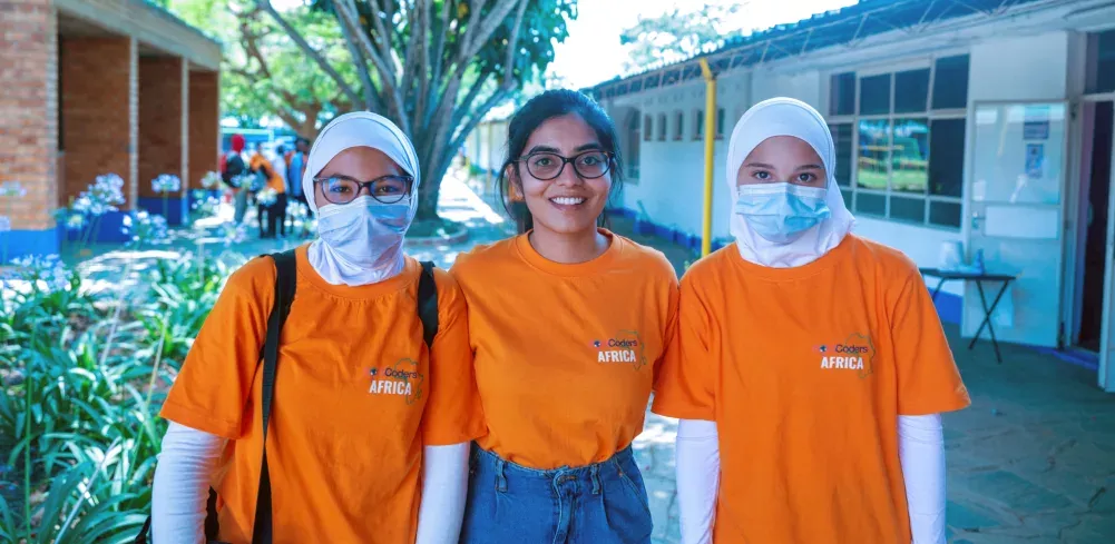 Kavya Krishna with two others, all wearing orange shirts