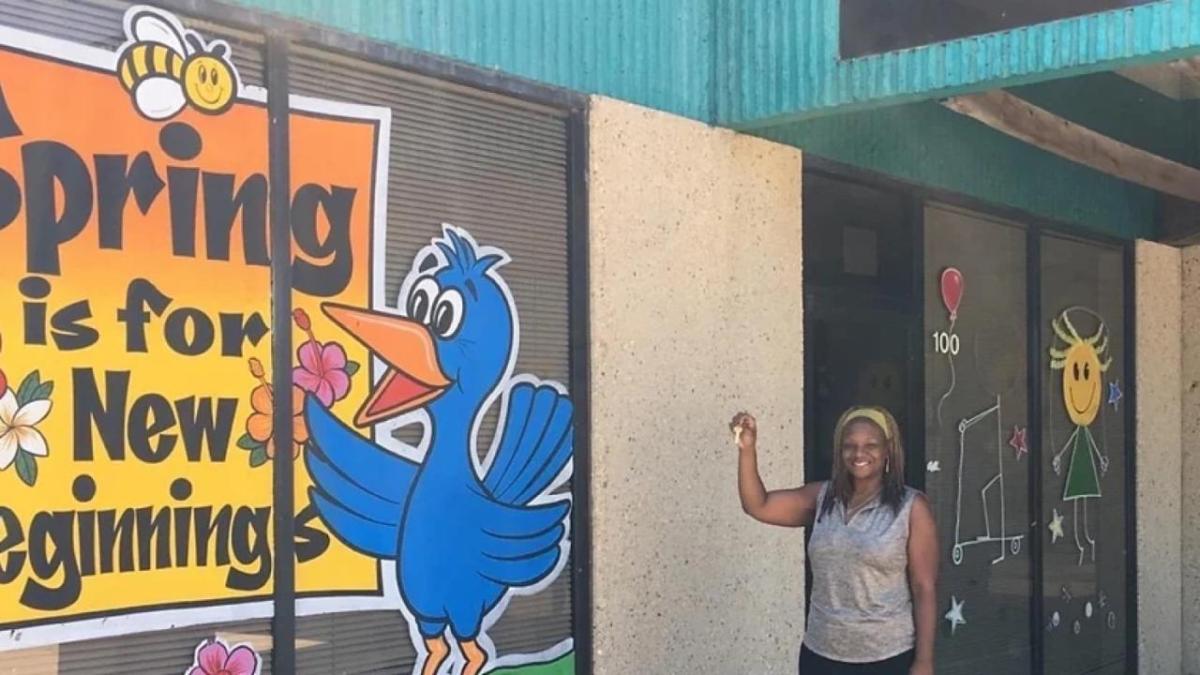 A person holding up a set of keys outside Bailey’s Child Development and Learning Center