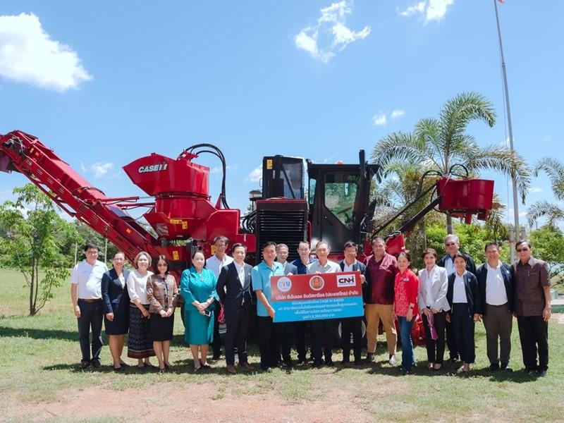 Group of people stood in front of a piece of agricultural machinery 