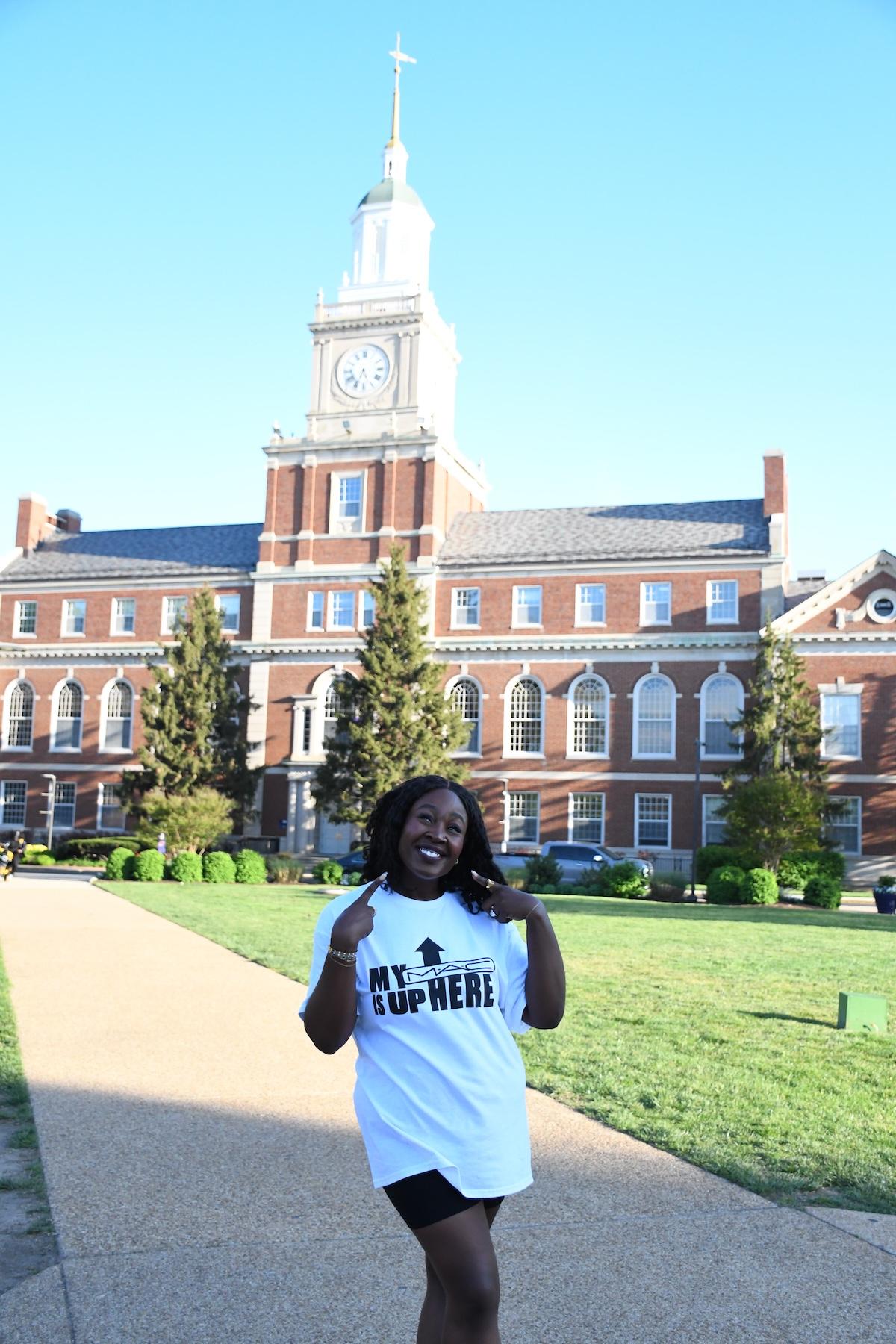 person smiling in front of brick building