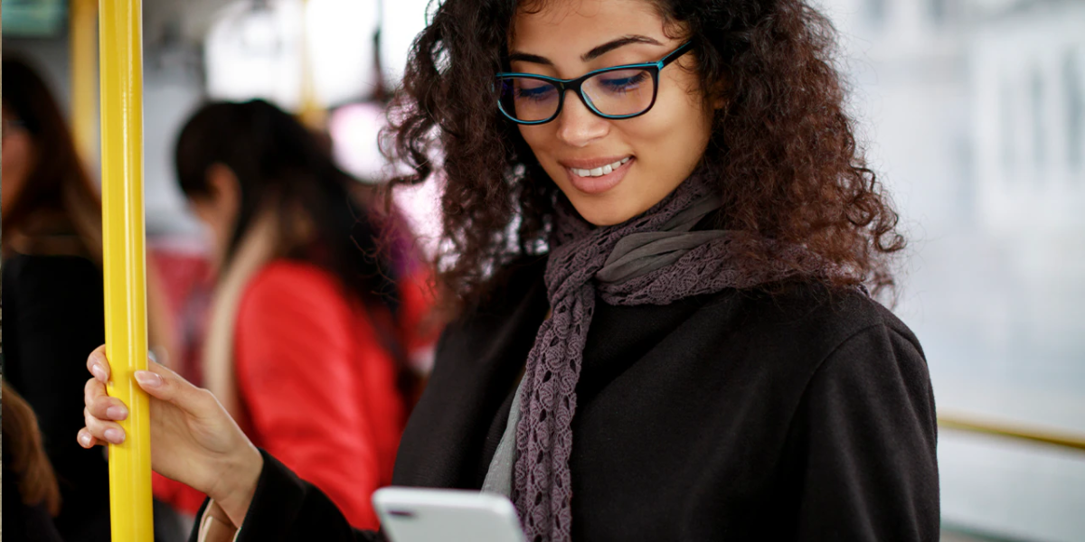 smiling woman on her phone on public transportation