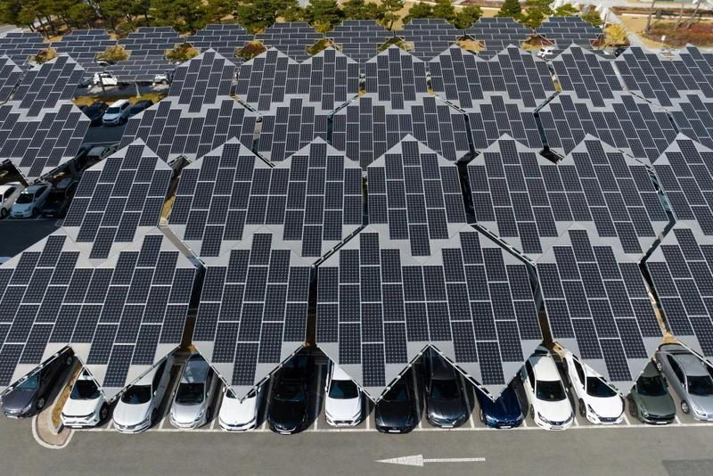 Aerial view of a parking garage roof covered in solar panels