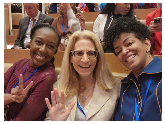 Three people in a selfie seated in an auditorium.