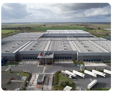 Aerial view of a large warehouse with semi trucks parked in front.