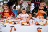 The Home Depot Kids Workshop. Kids shown at a table making crafts and gifts.