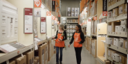 Kierra Blake and an employee walking through aisle in Home Depot store