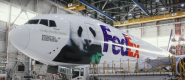 Photo of a large plane in an airplane hangar with the FedEx logo and an image of a giant panda on the side along with the words, "FedEx Panda Express"