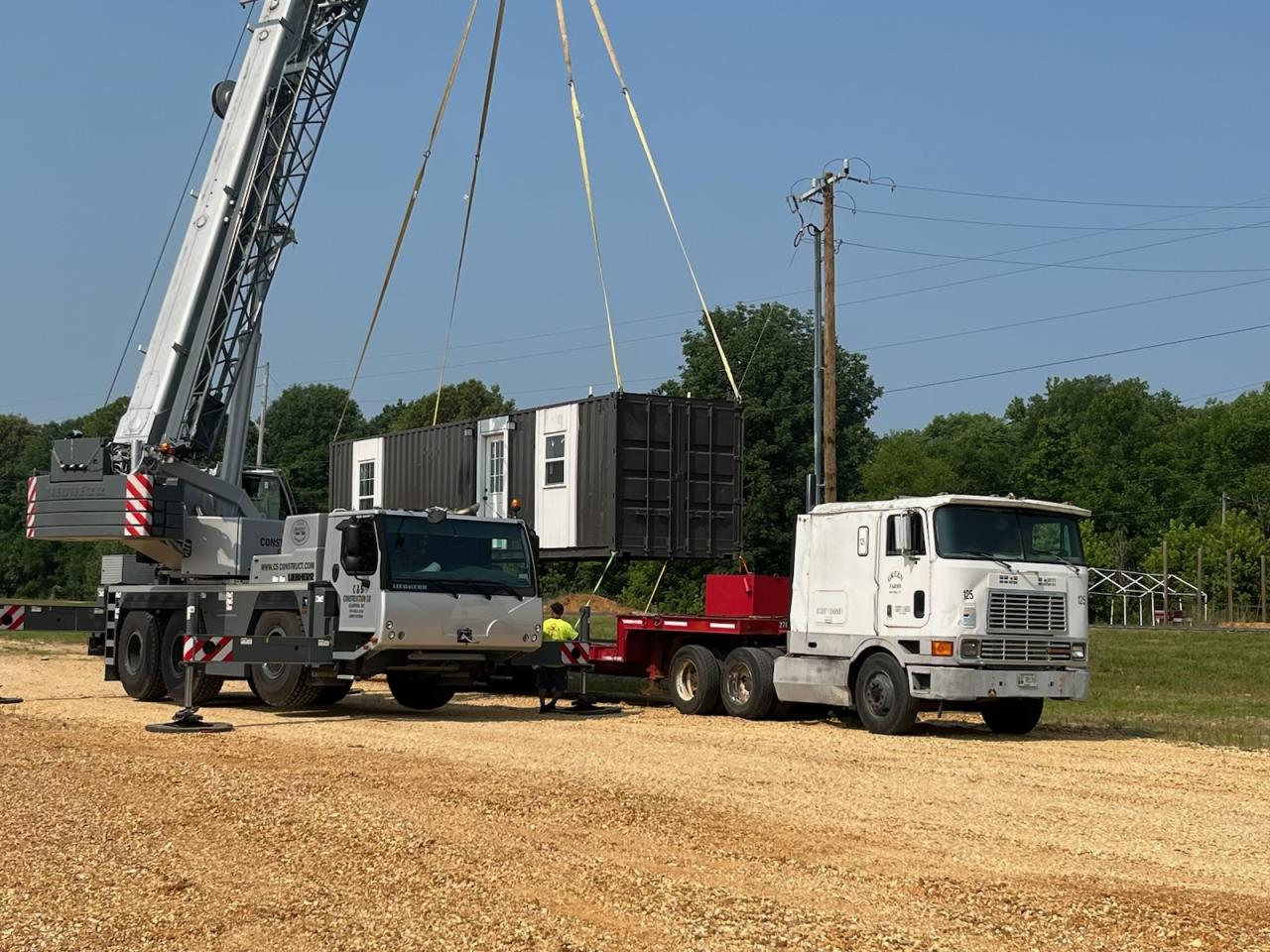 Container being placed on truck by crane