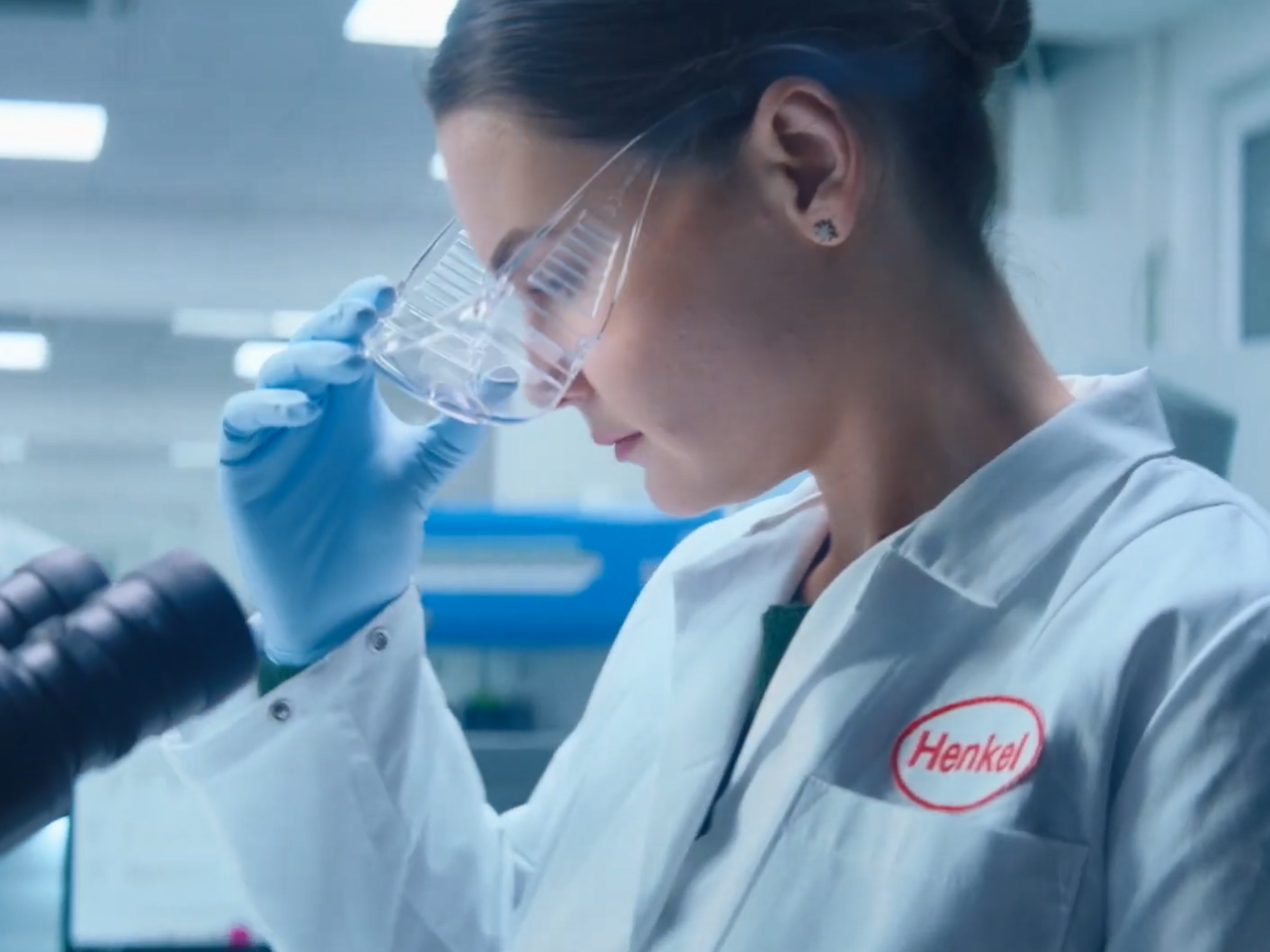 A person putting on protective eye wear in a lab setting.