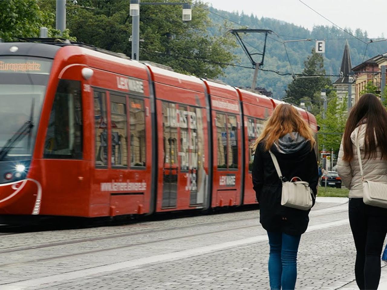 Two people walking next to a train