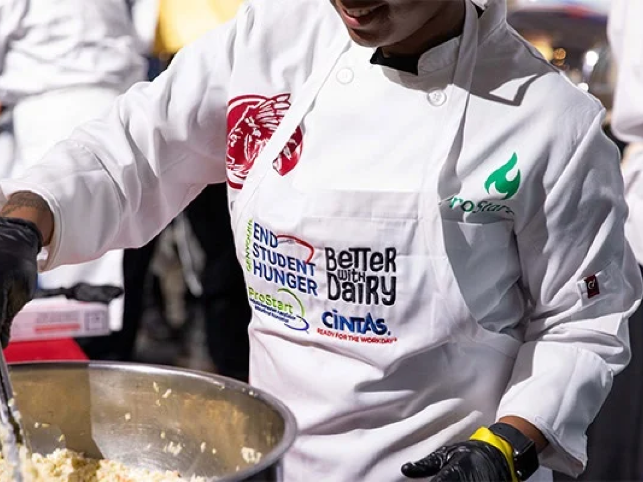 A chef cooking food in a big pot