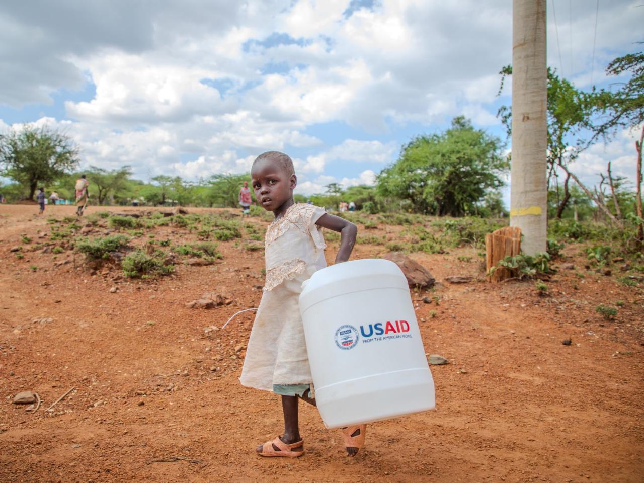 A girl carries water home in Kenya. 