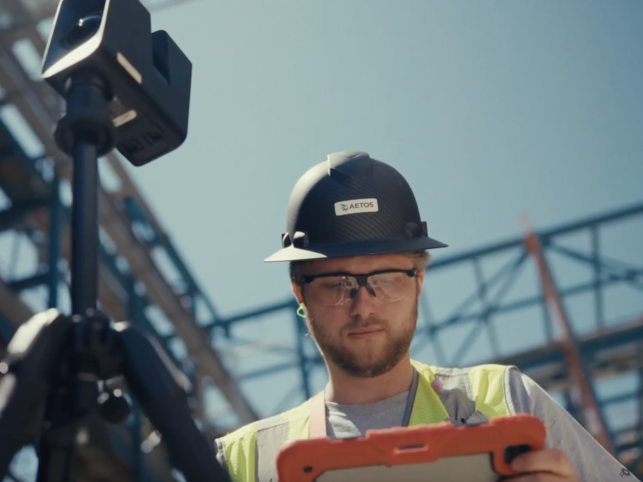 Worker in hardhat consulting tablet at a construction site