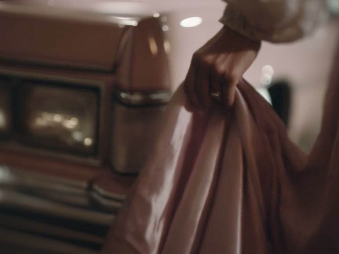 hand removing cover from pink car