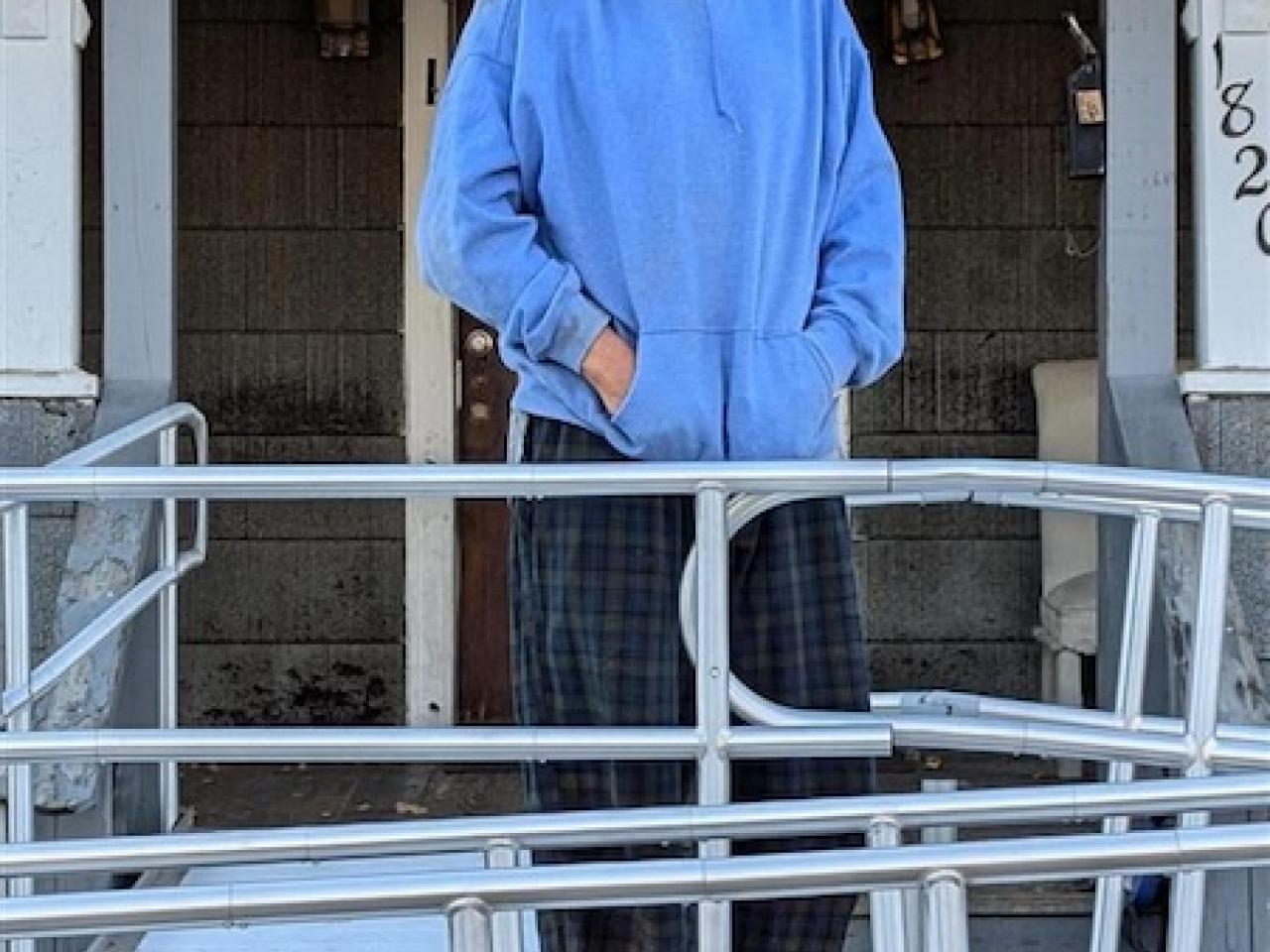 Roy shown in front of his house on the wheelchair ramp.