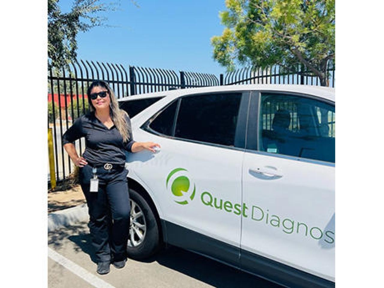 Esmeralda Bonilla standing next to a Quest vehicle