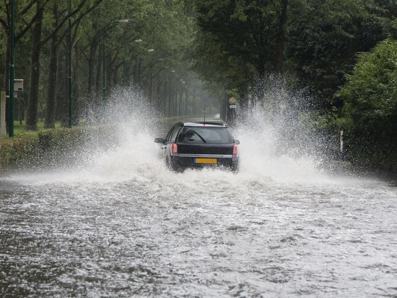 A car driving thorough a flooded street