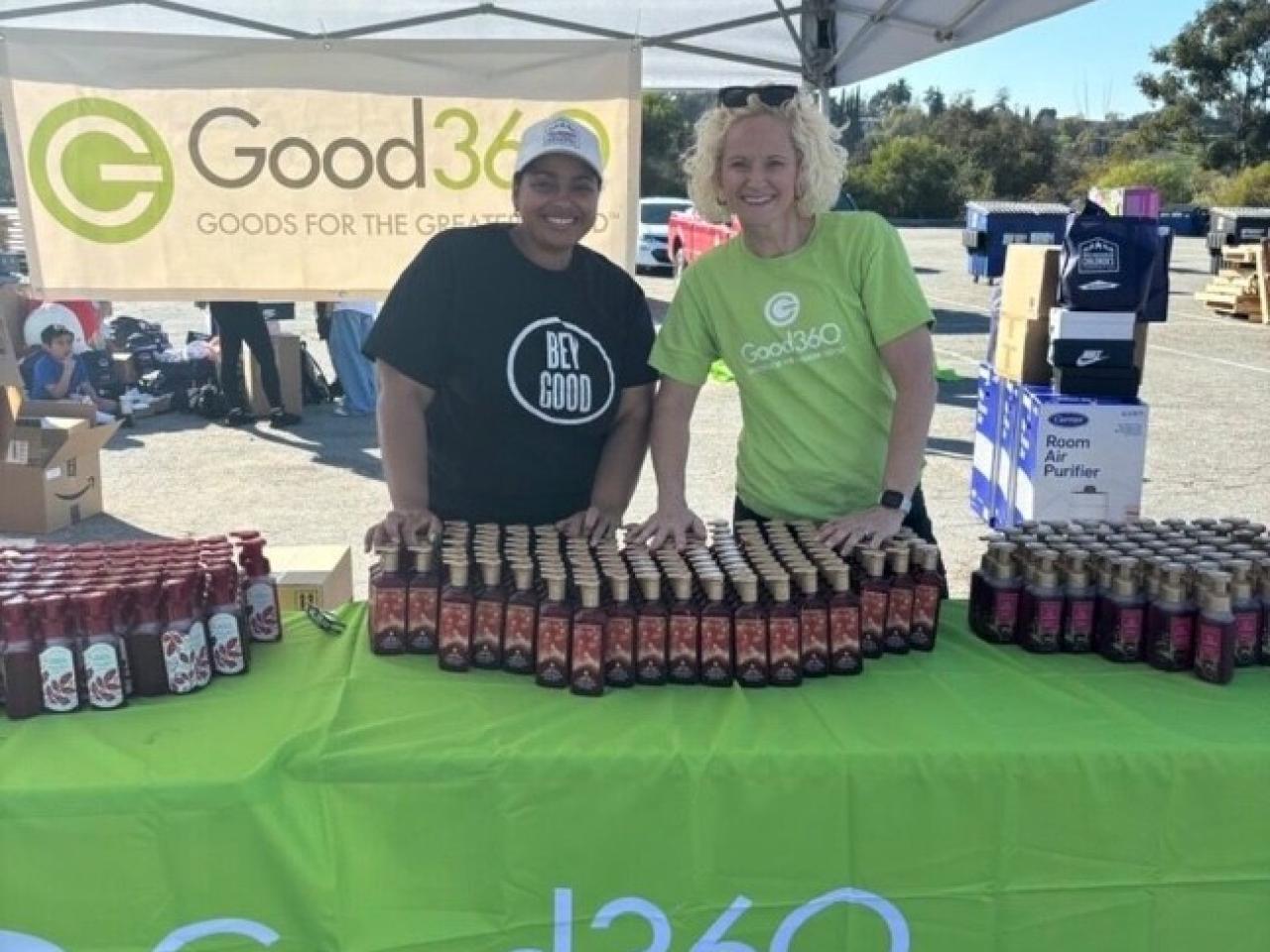 Two people standing at the Good360 booth