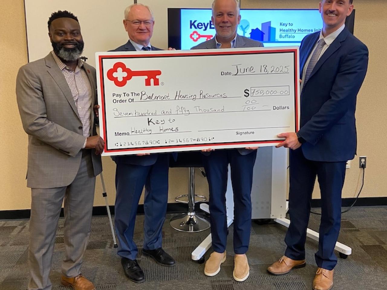 Representatives from KeyBank and Belmont Housing Resources shown with a $750,000 grant check.