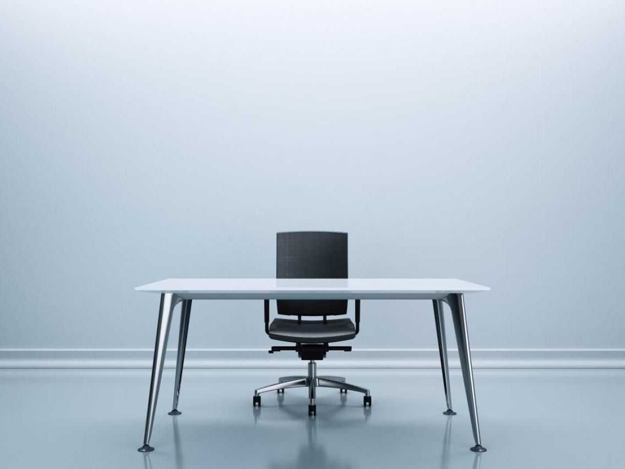 Desk and chair in the center of an empty room