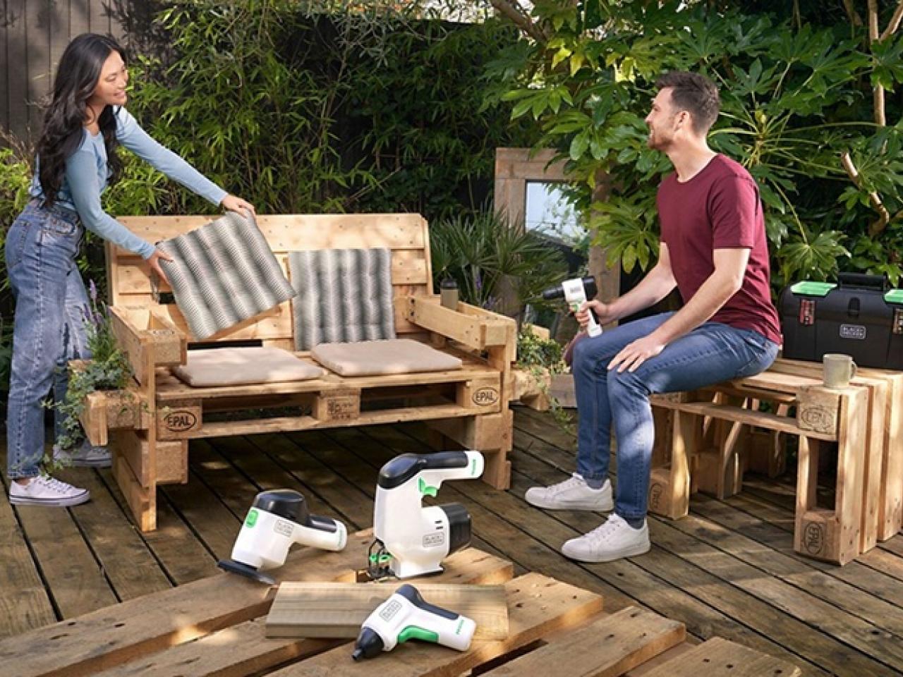 People using tools to build furniture out of wood pallets 