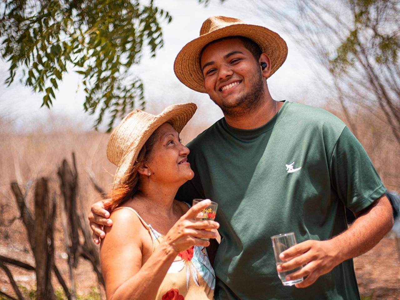 Two people standing together with glasses of water