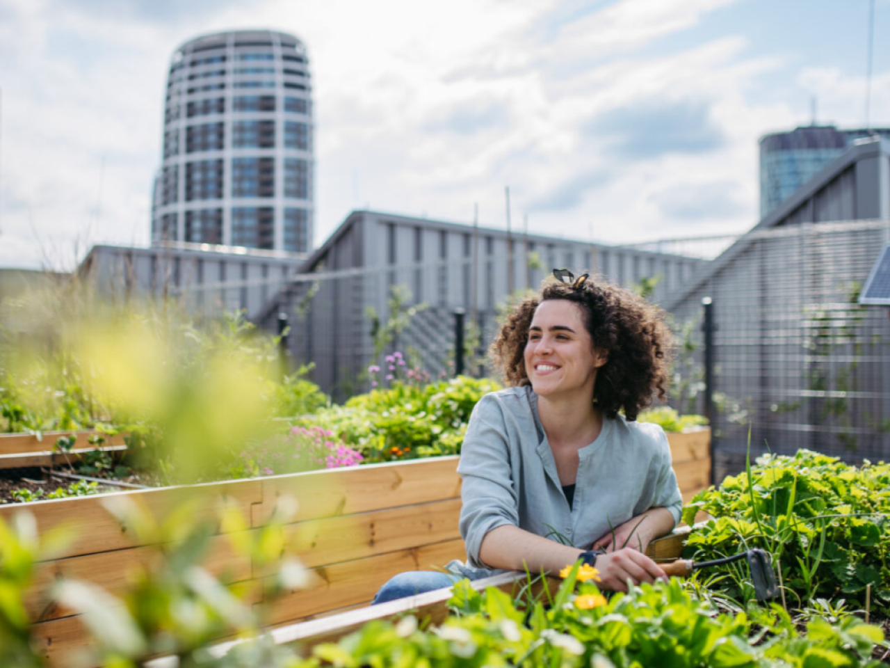 Woman smiling next to a garden bed