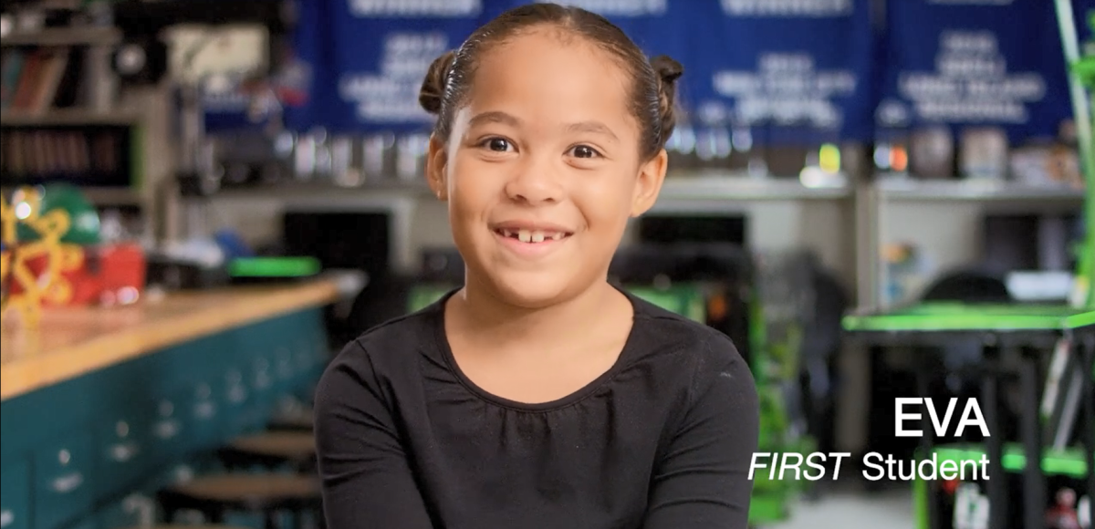 Eva, a school child, sitting in a classroom, smiling at the camera.