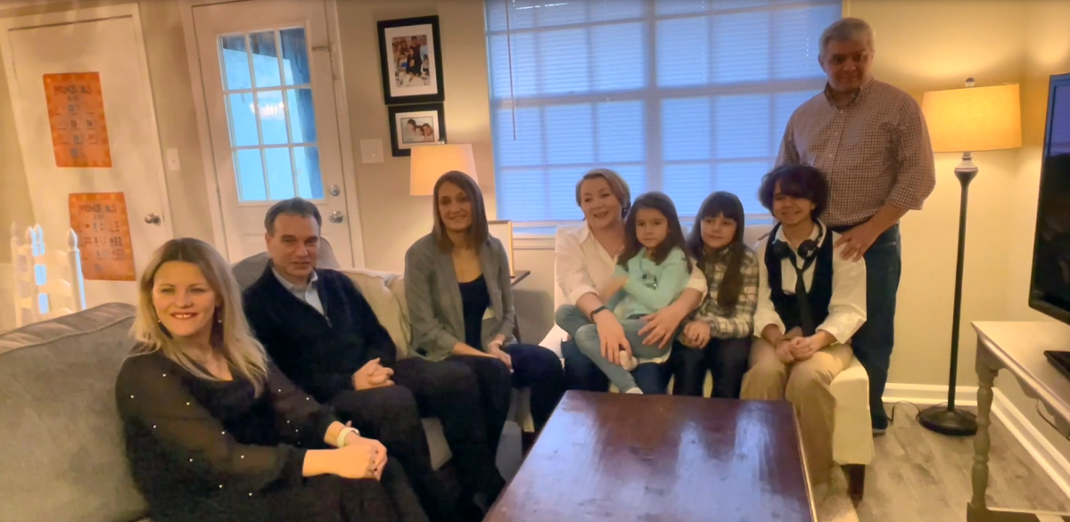 Associates and family sit down in a living room