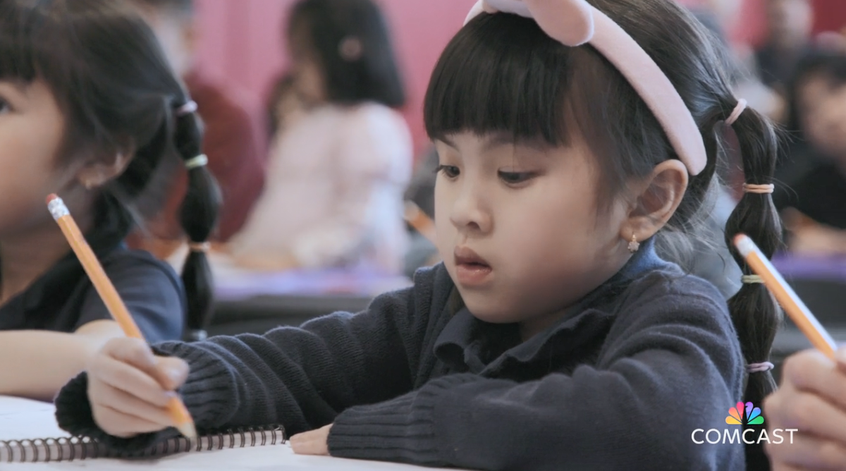 Children sketching in a room of others.