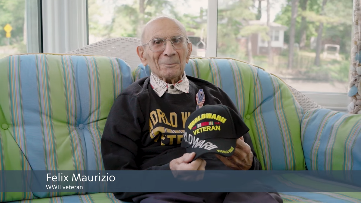 Felix Maurizio sat on a sofa holding a hat