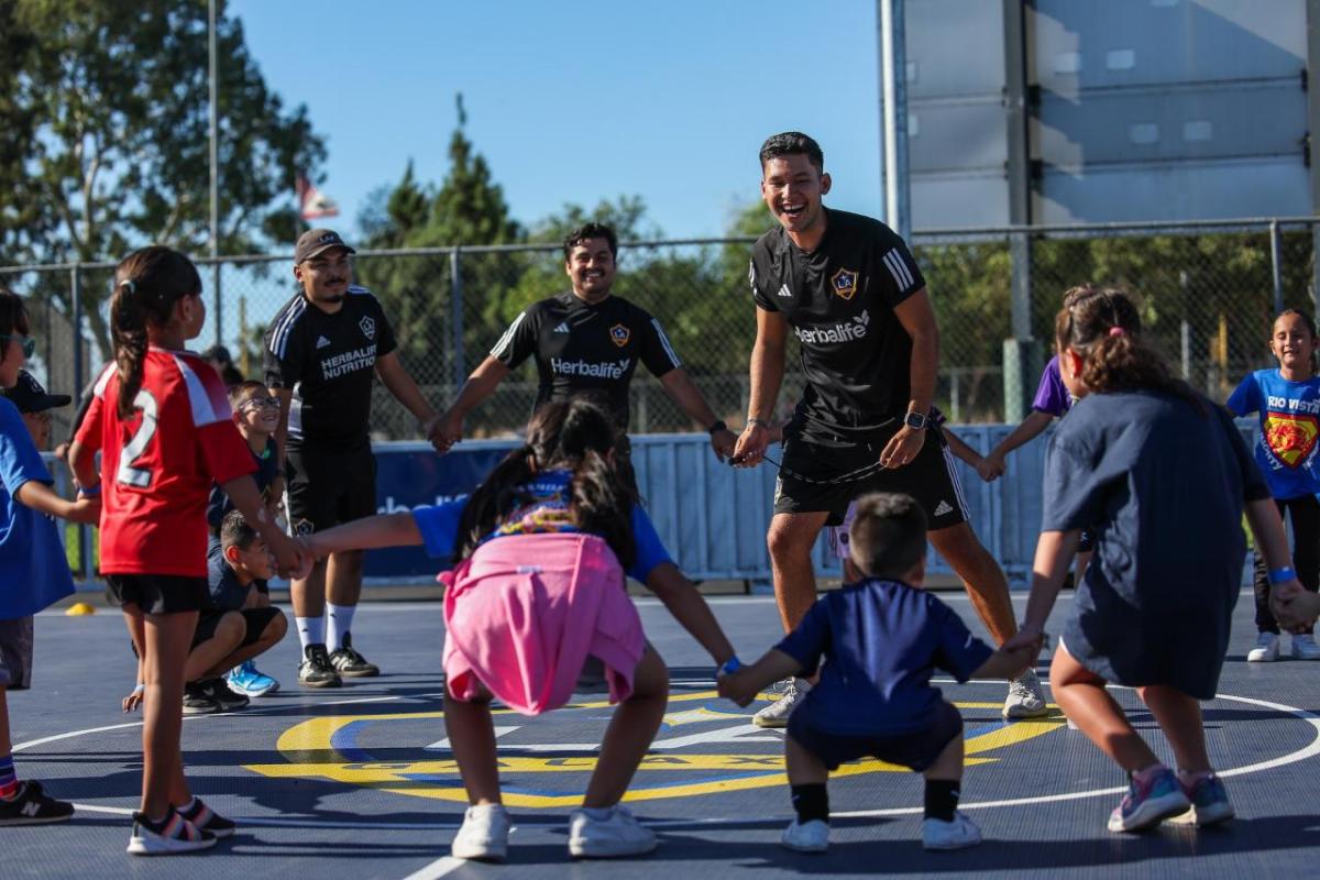 LA Galaxy players Jalen Neal, Edwin Cerrillo, and Mauricio Cuevas played with students on the new mini-pitch.