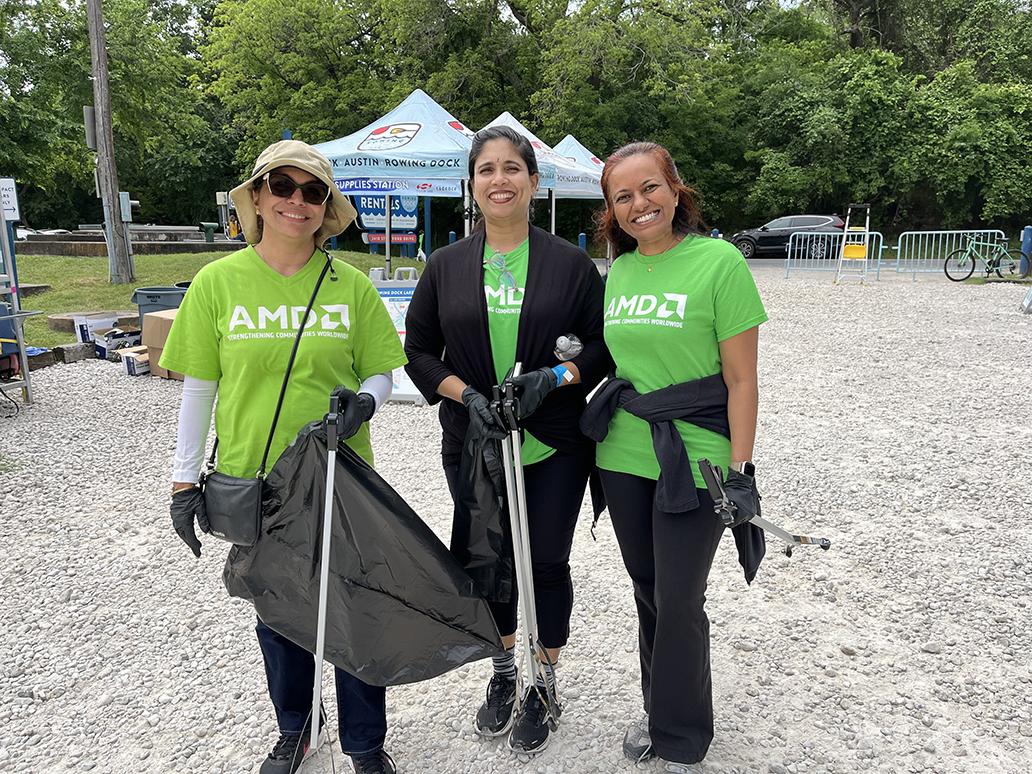 Three people standing together in green AMD t-shirts