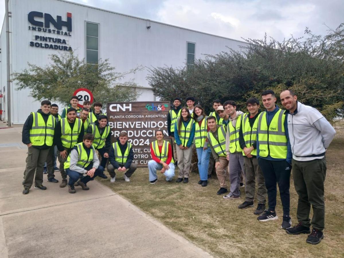 People in safety vests standing next to a sign for CNH