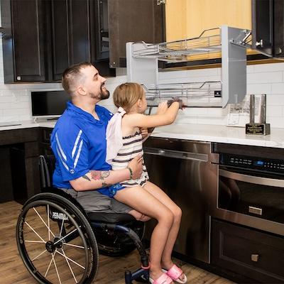 Veteran in a wheelchair shown holding his daughter.