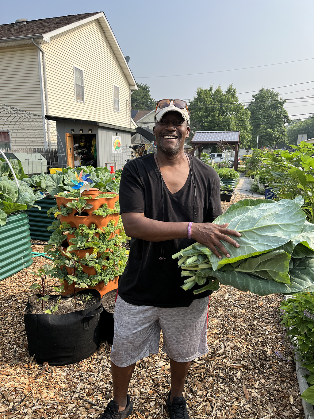 A person in a garden holding greens