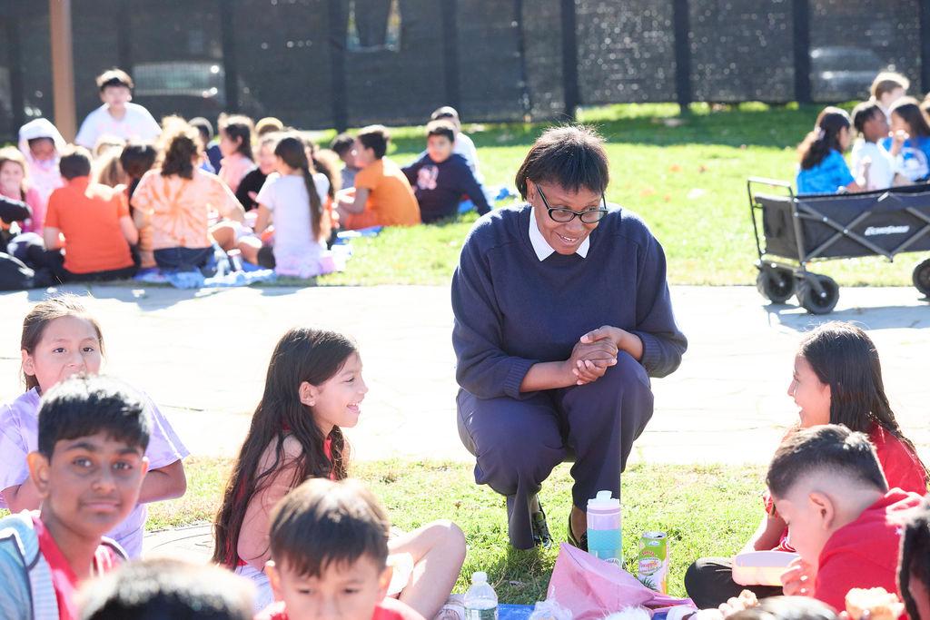 Children sat outside on the grass