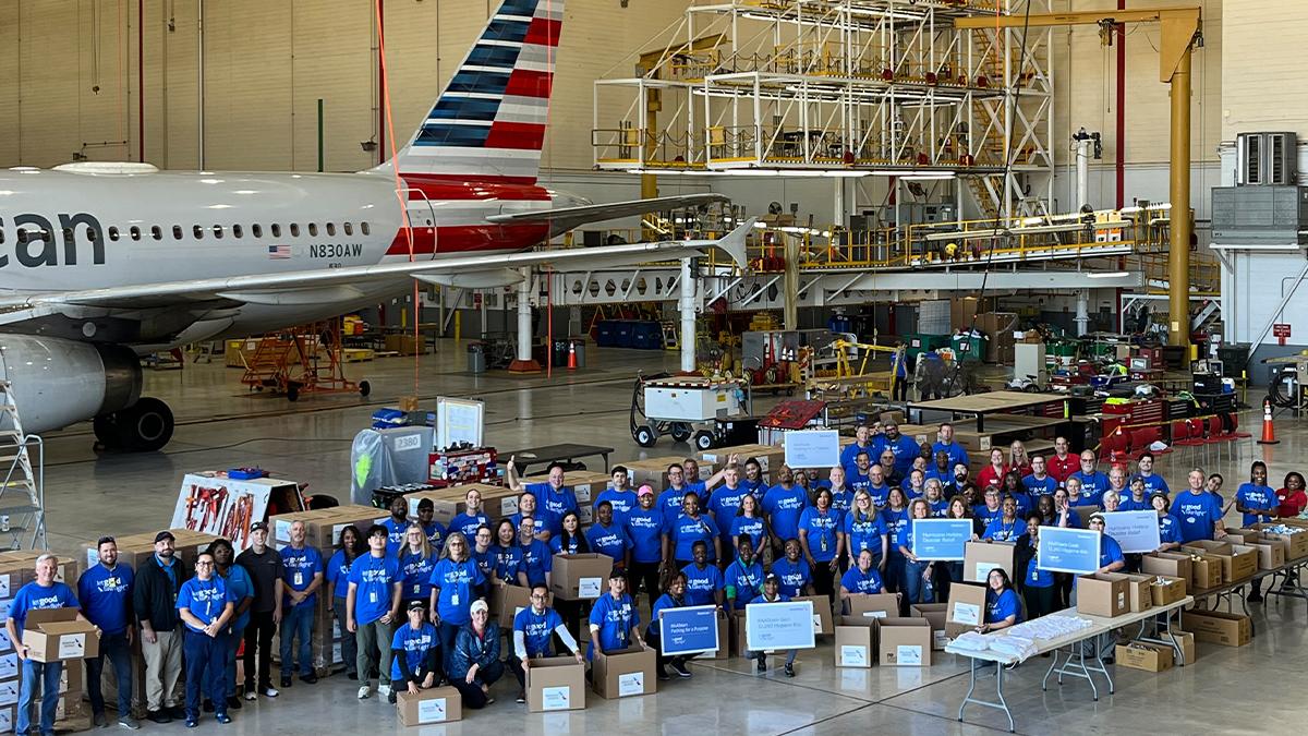 Volunteers stood besides boxes in front of an American Airlines plane