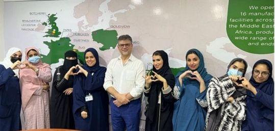 A large group photo of people make love heart signs with their hands