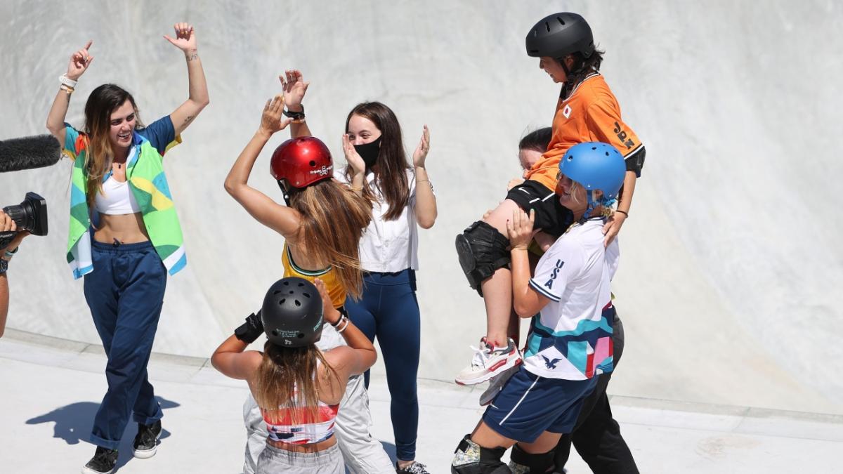 Women skateboarders lifting fellow skater Misugu Okamoto after a fall