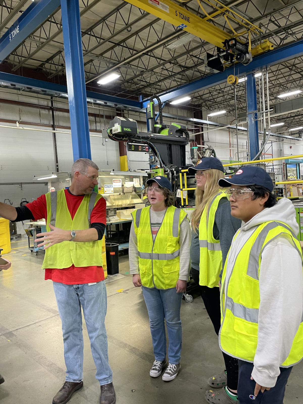 Group of people in hi-visibility vests in a factory