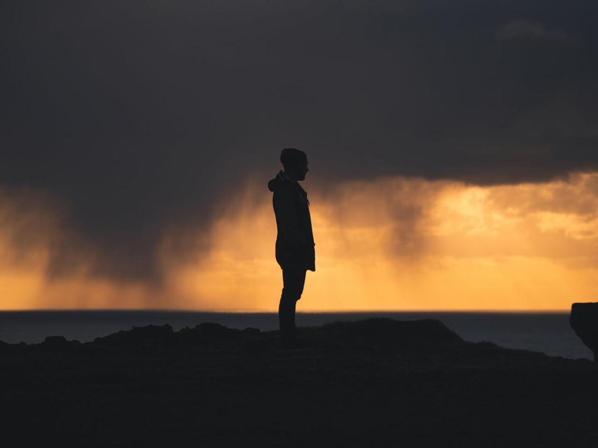 A silhouette of a person stood on a hill