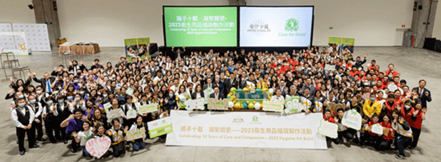 A large group of people posing behind a banner