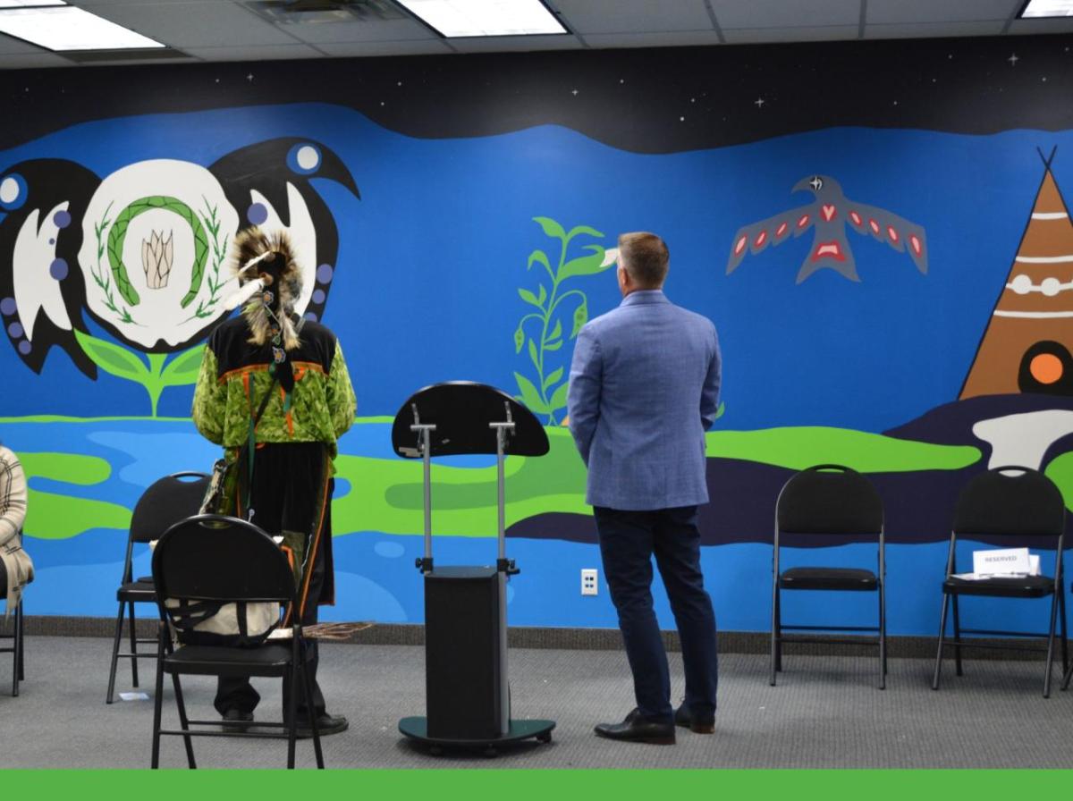 Two people shown from the back, looking at a large mural