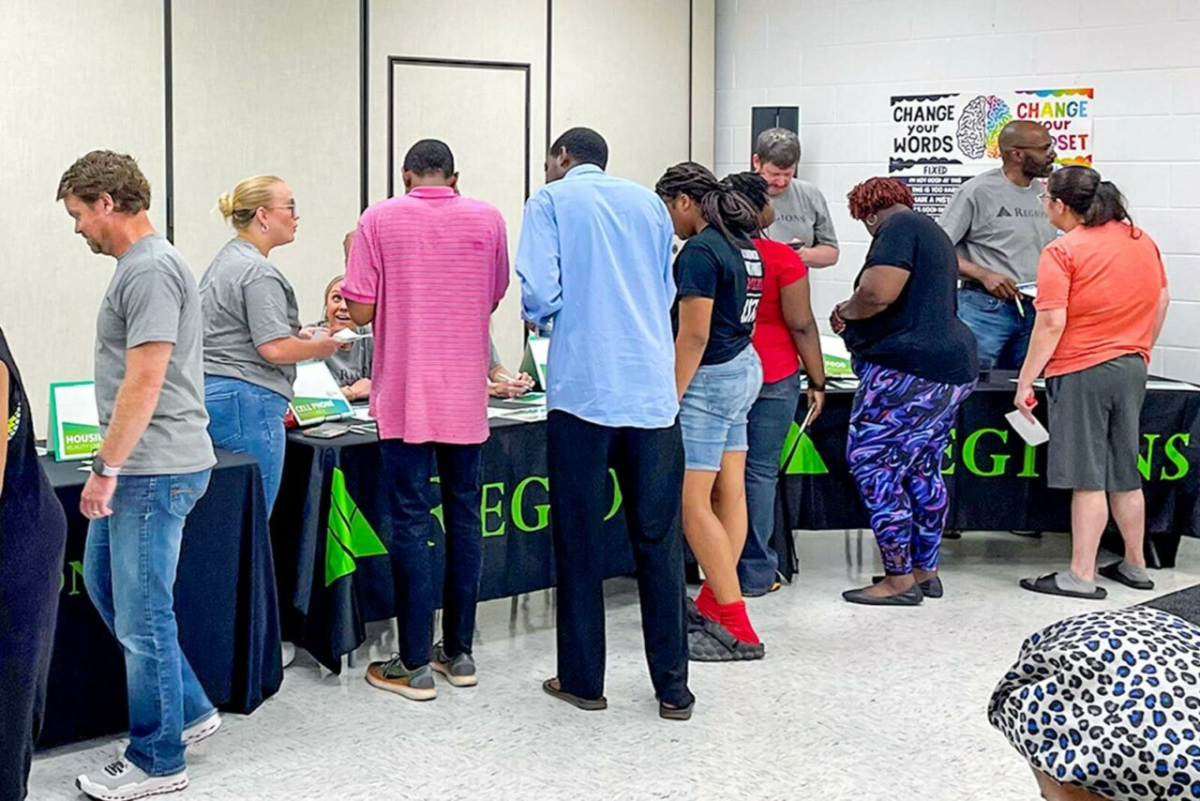 People walking around tables at an event